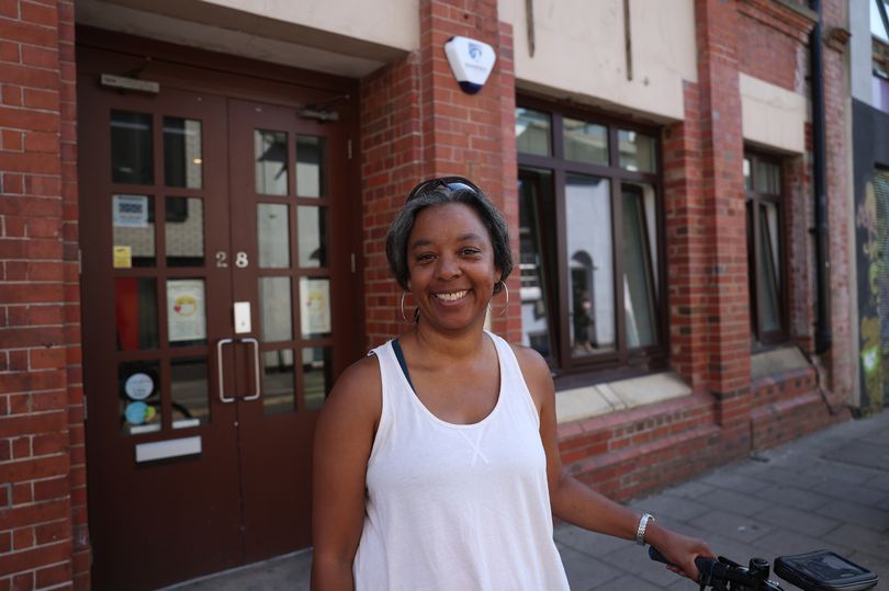 Black woman standing in front of her bookshop